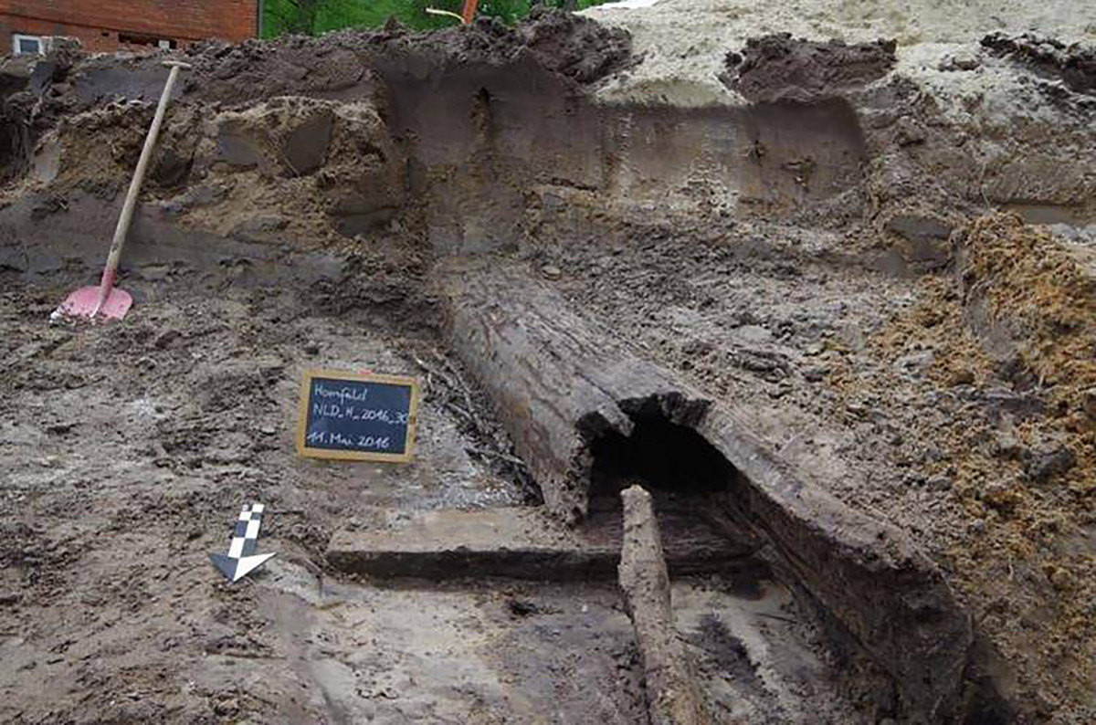 Das hölzerne Gerinne während der Freilegung. Links im Bild sind die Ruten und das Reisig zur Verfestigung zu erkennen.